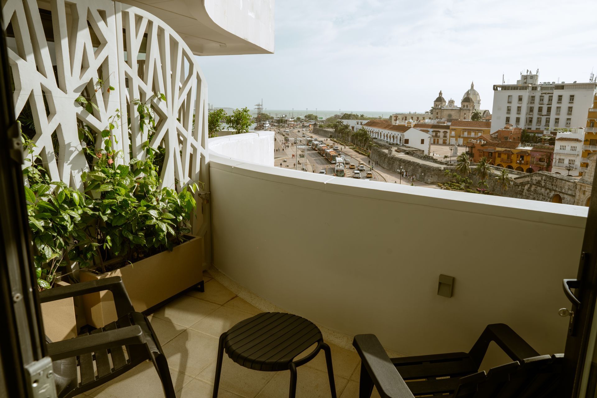 Un balcón con dos sillas y una mesa con vista a una ciudad.