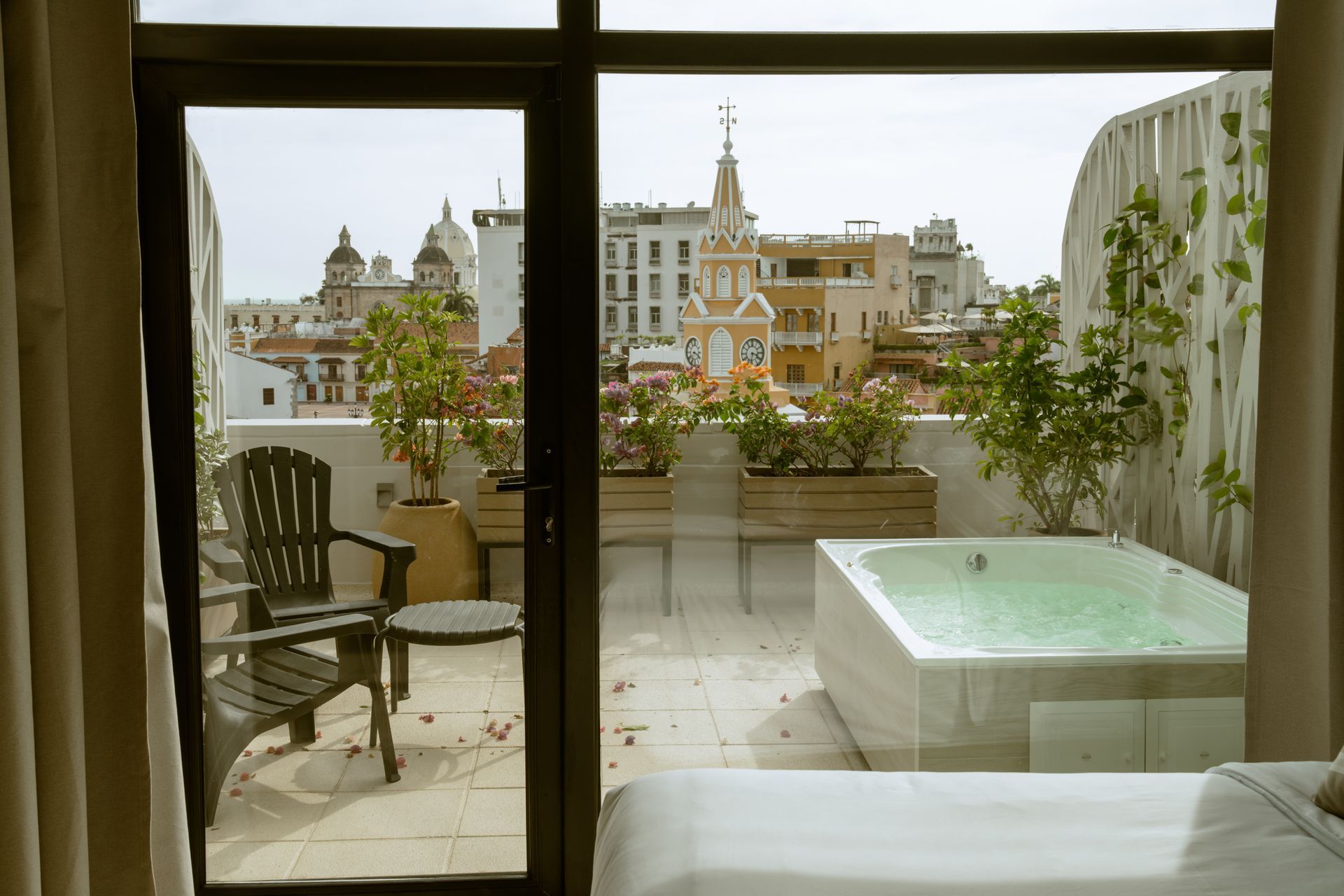 Una habitación de hotel con bañera de hidromasaje y vistas a la ciudad.