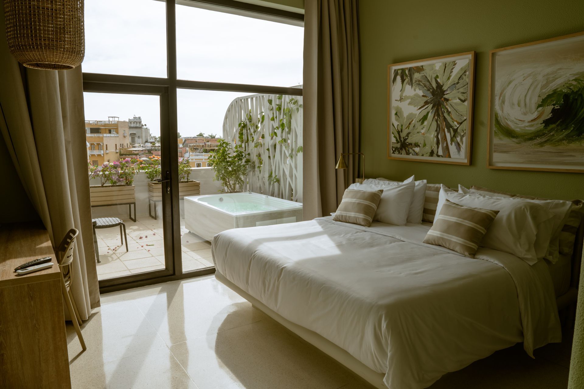 Una habitación de hotel con una cama grande y un jacuzzi en el balcón.