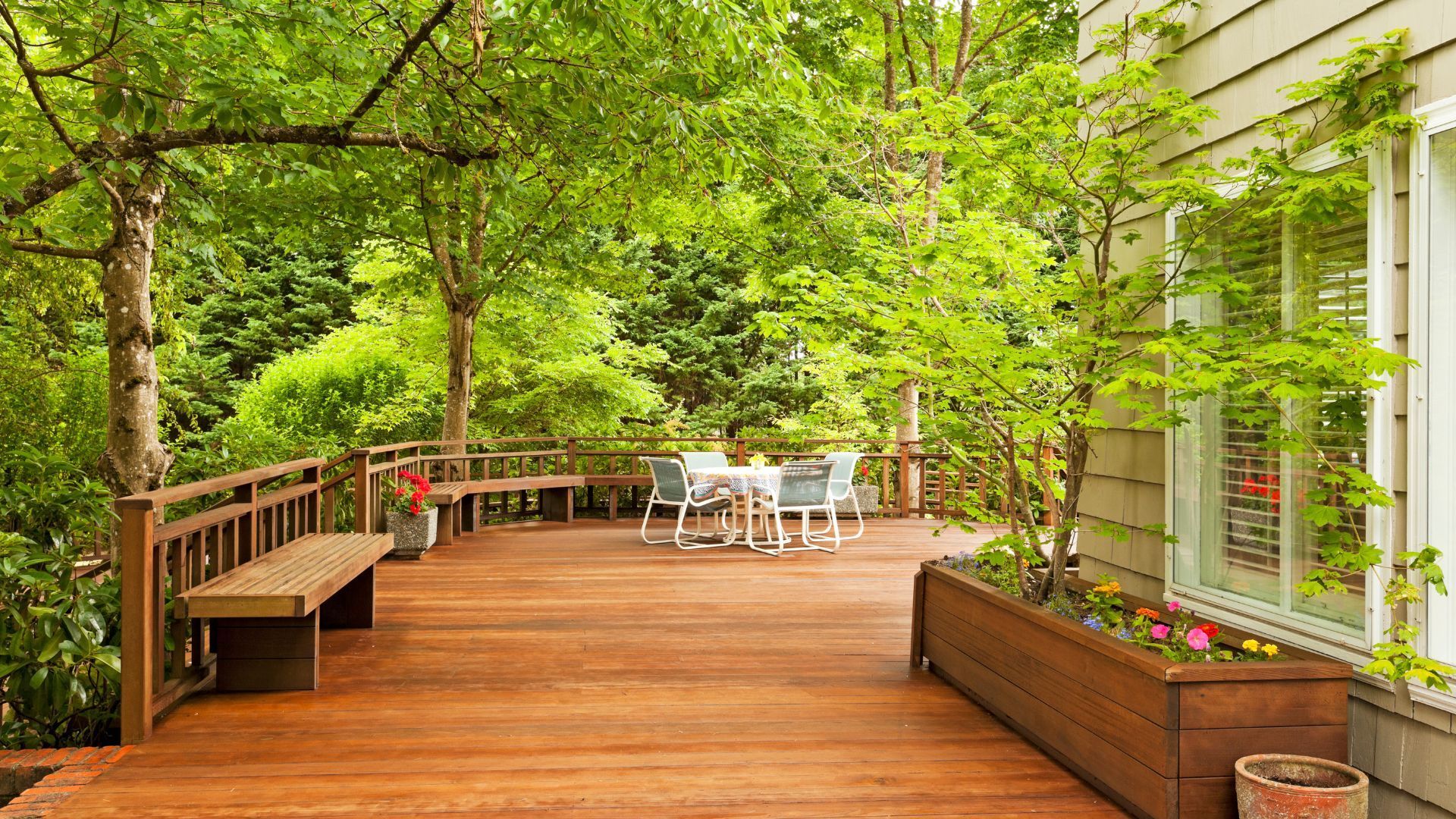 Warm wooden deck with seating and patio set, surrounded by Saint Paul's lush foliage.