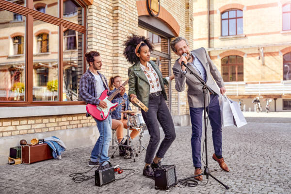 A group of people are playing instruments and singing into microphones.