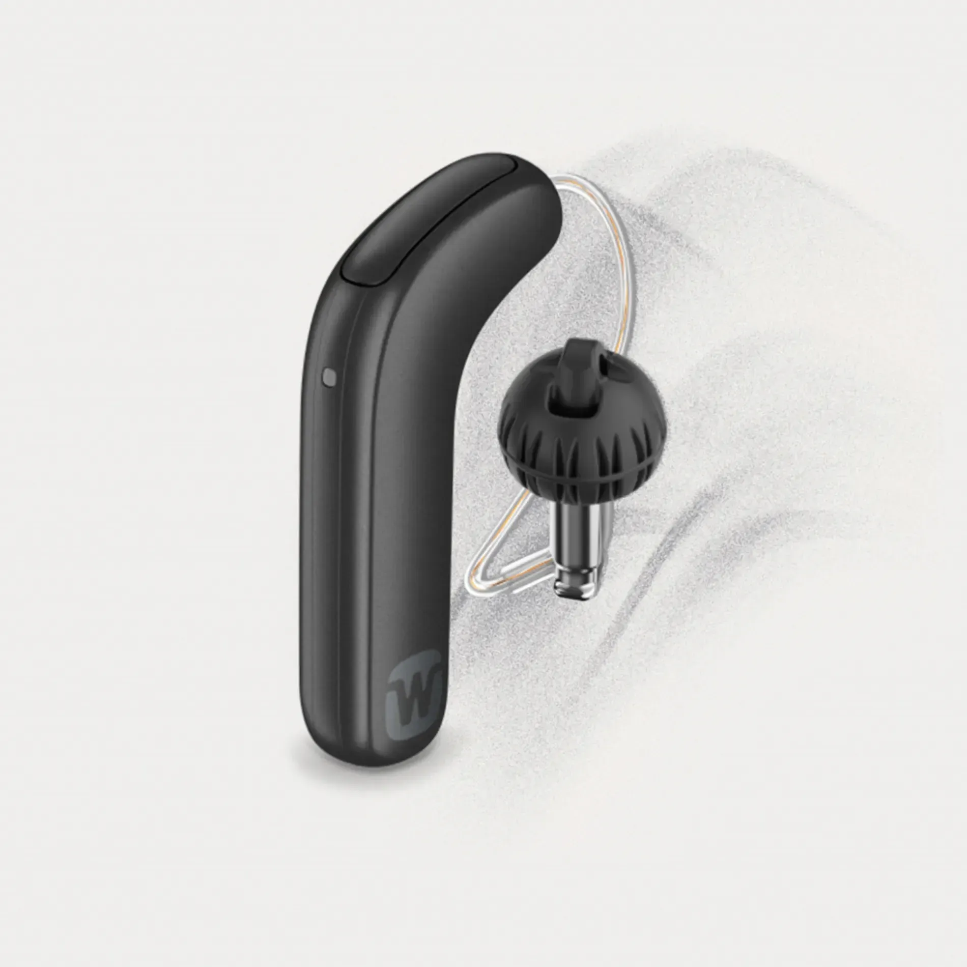 A black hearing aid is sitting on a white surface.