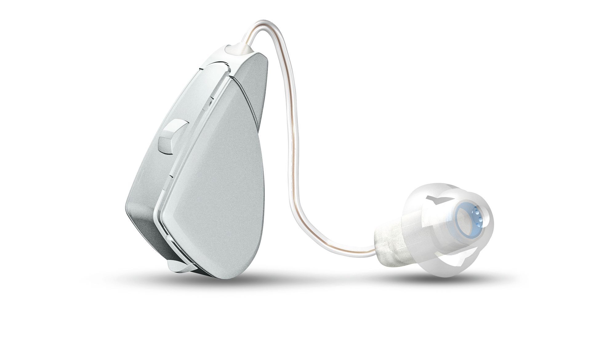 A white hearing aid is sitting on a white surface.