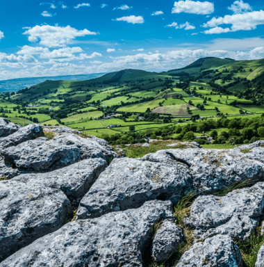 A view of a valley from the top of a rocky hill.