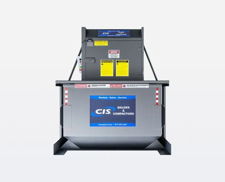 Front view of a silver CIS baler compactor with safety warnings. The compactor is in a light setting.
