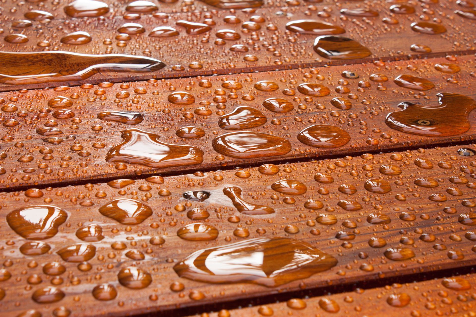 A close up of water drops on a wooden surface