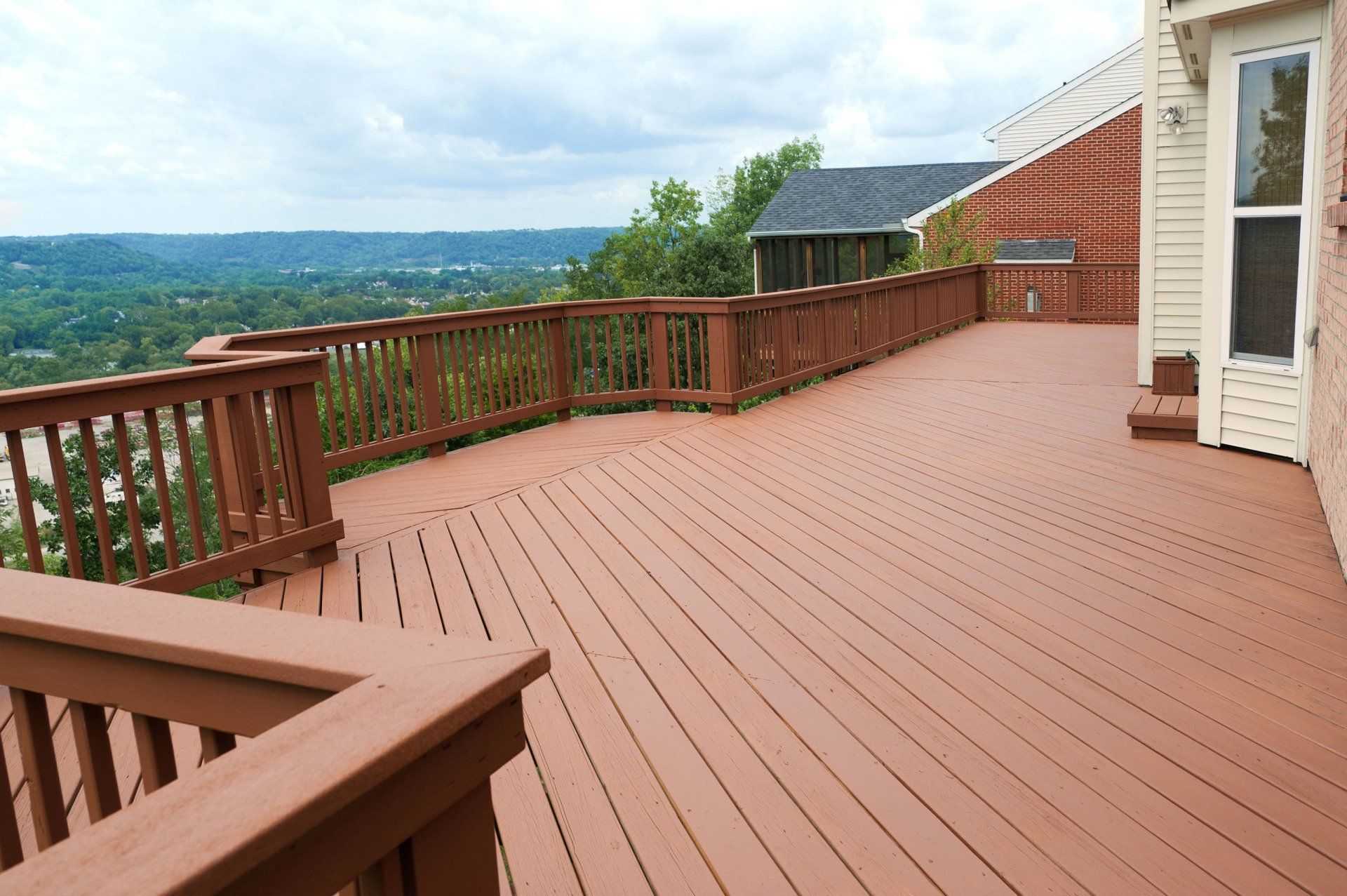 A large wooden deck with a view of a city