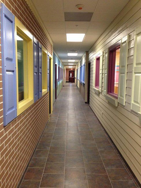 A long hallway with many windows and shutters.