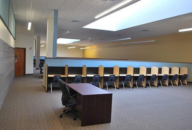 A large room with a desk and chairs in it.