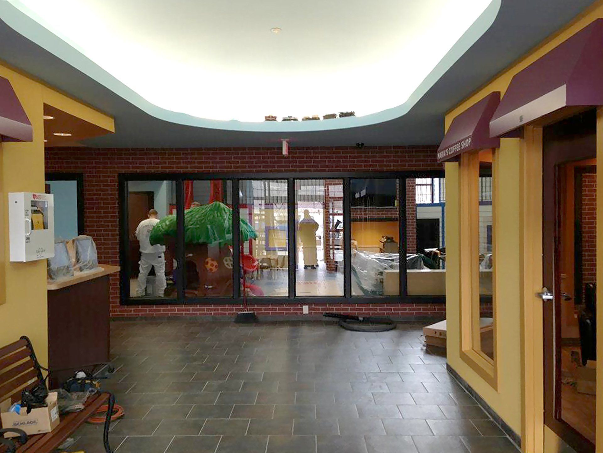 A hallway with a brick wall and a purple awning.