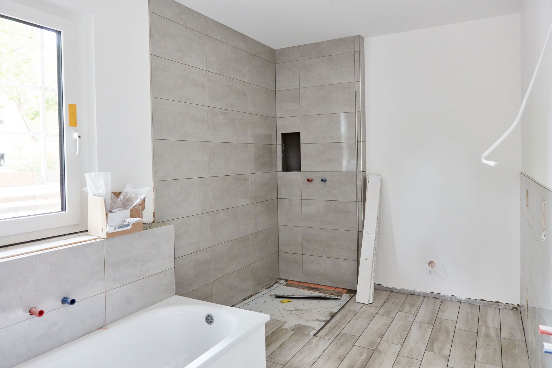A bathroom under construction with a bathtub and shower.