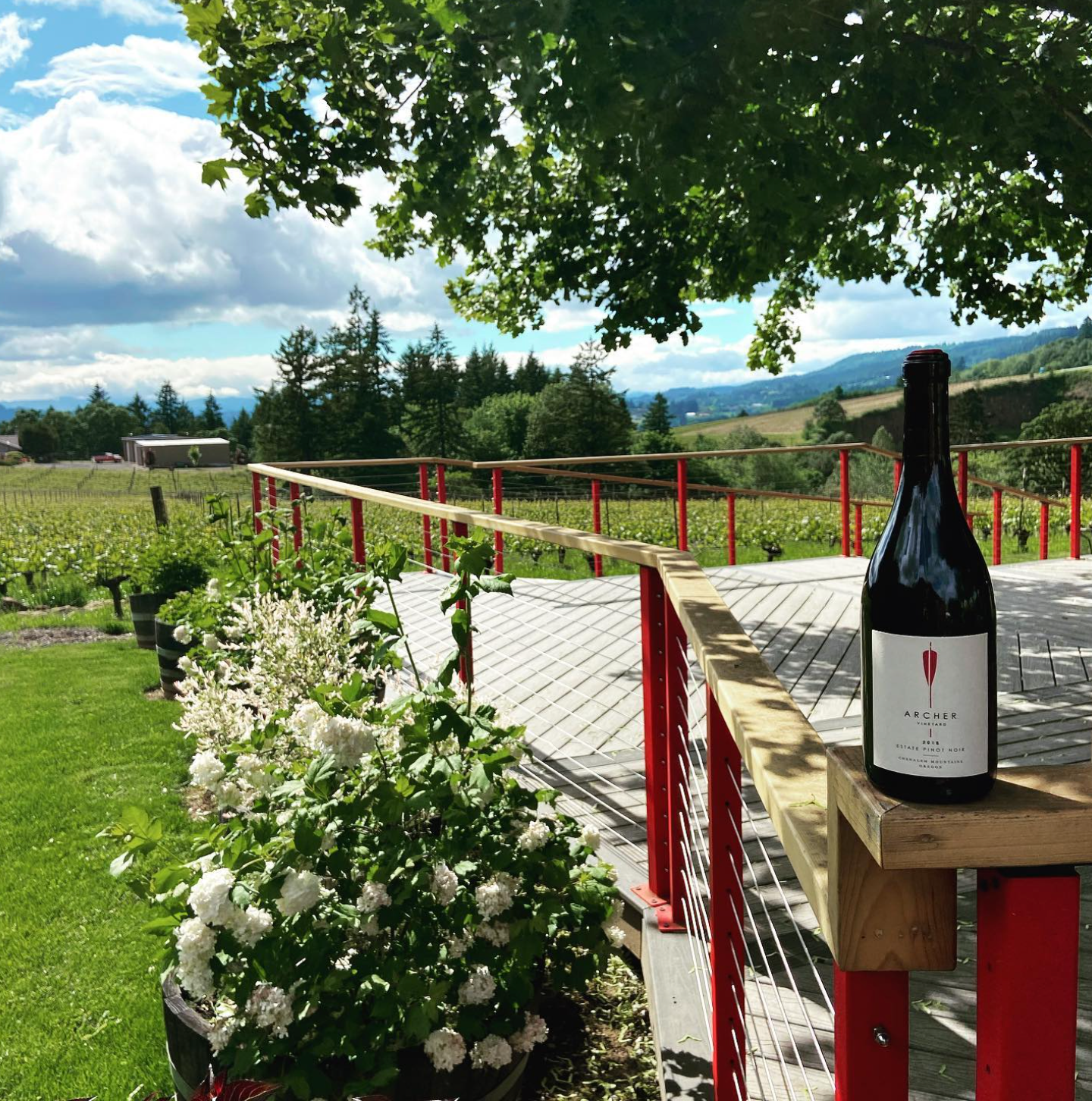 A glass of wine is sitting on a wooden post.