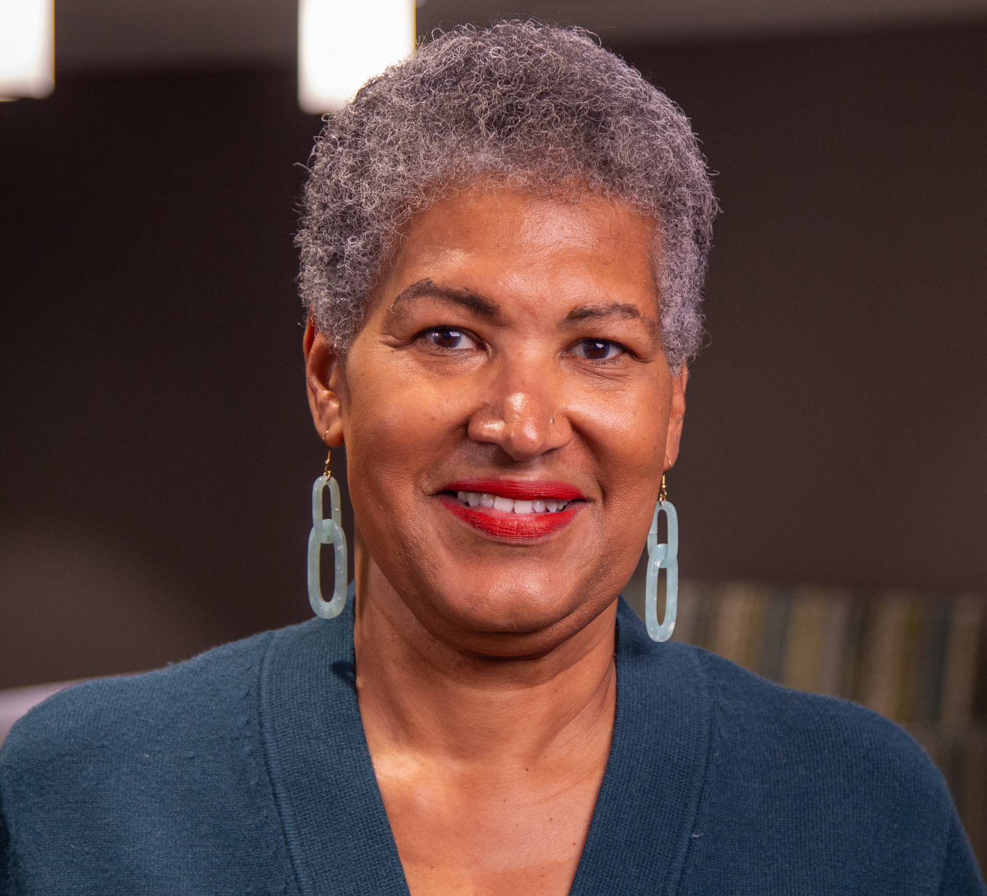 A man with a beard and glasses is smiling in front of a snowy forest.