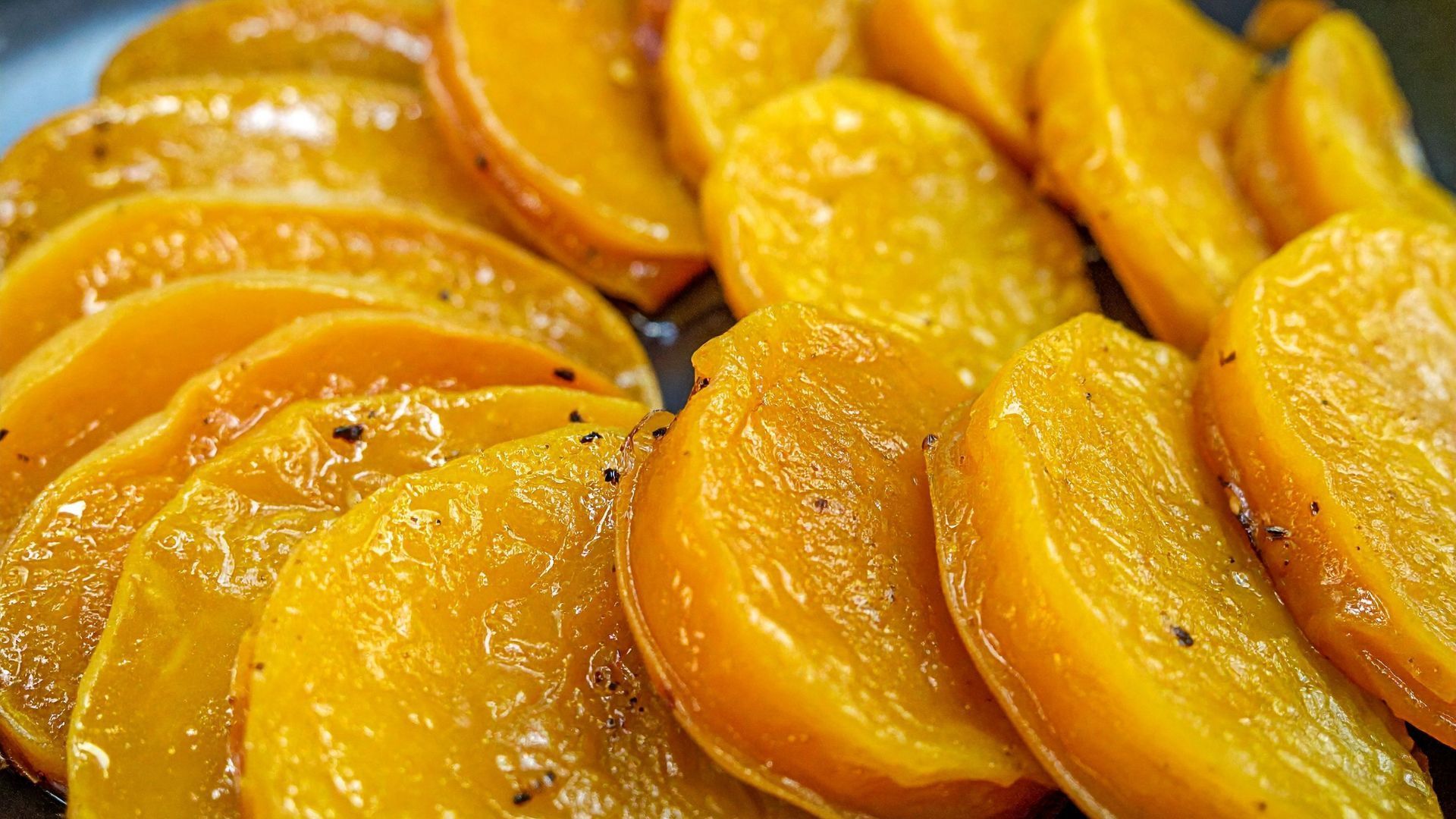 Sliced, roasted butternut squash, golden-brown and glistening.