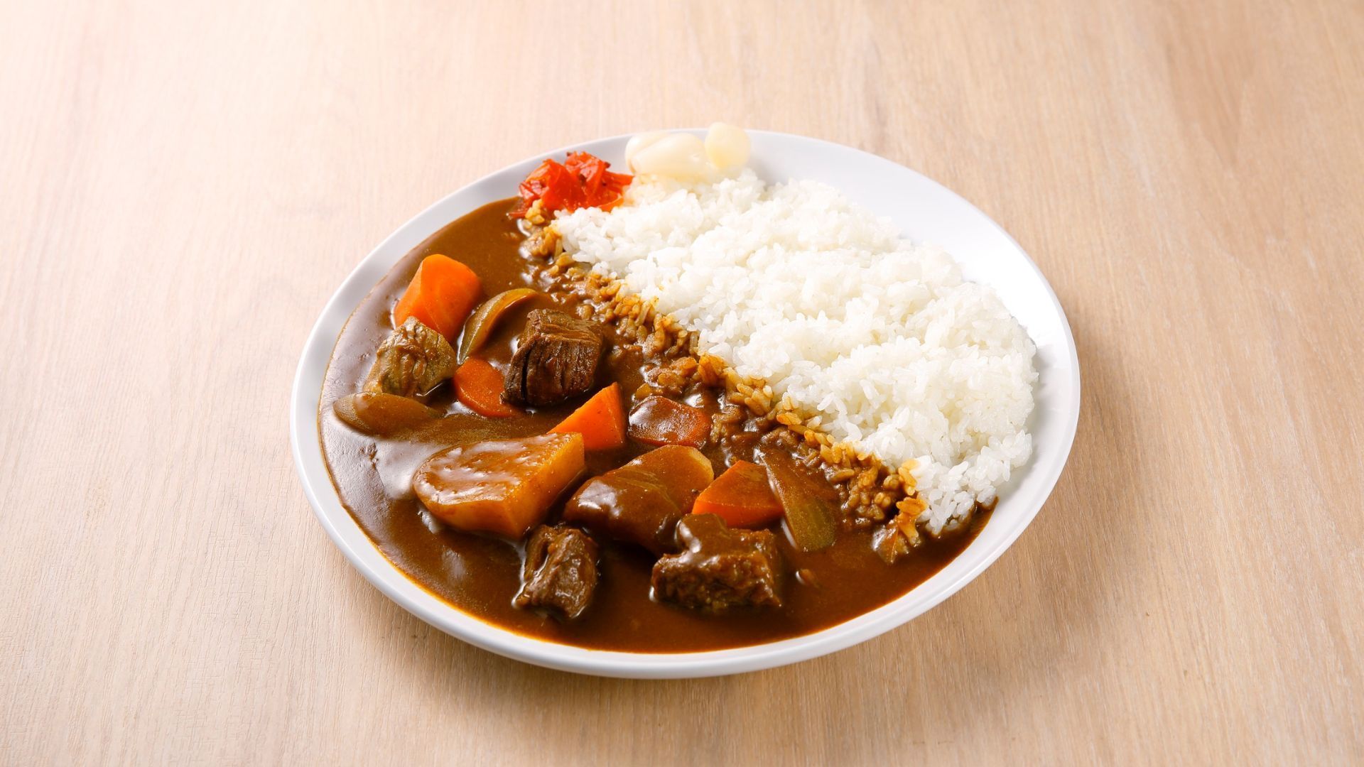 Plate of Japanese curry with rice, meat, and vegetables.
