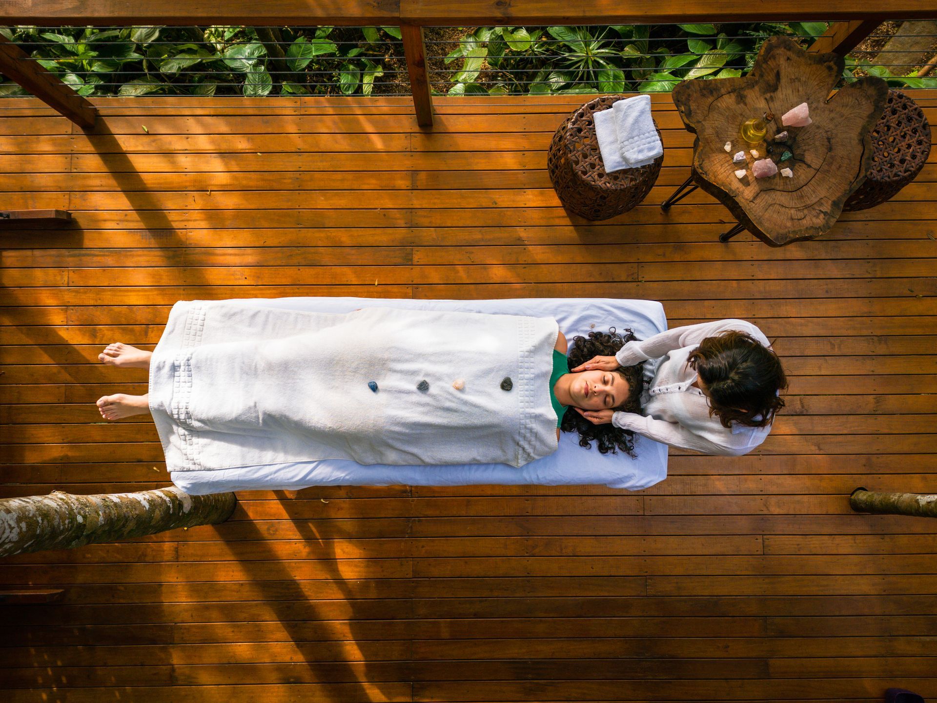 A woman is standing with her eyes closed and her hands on her chest.