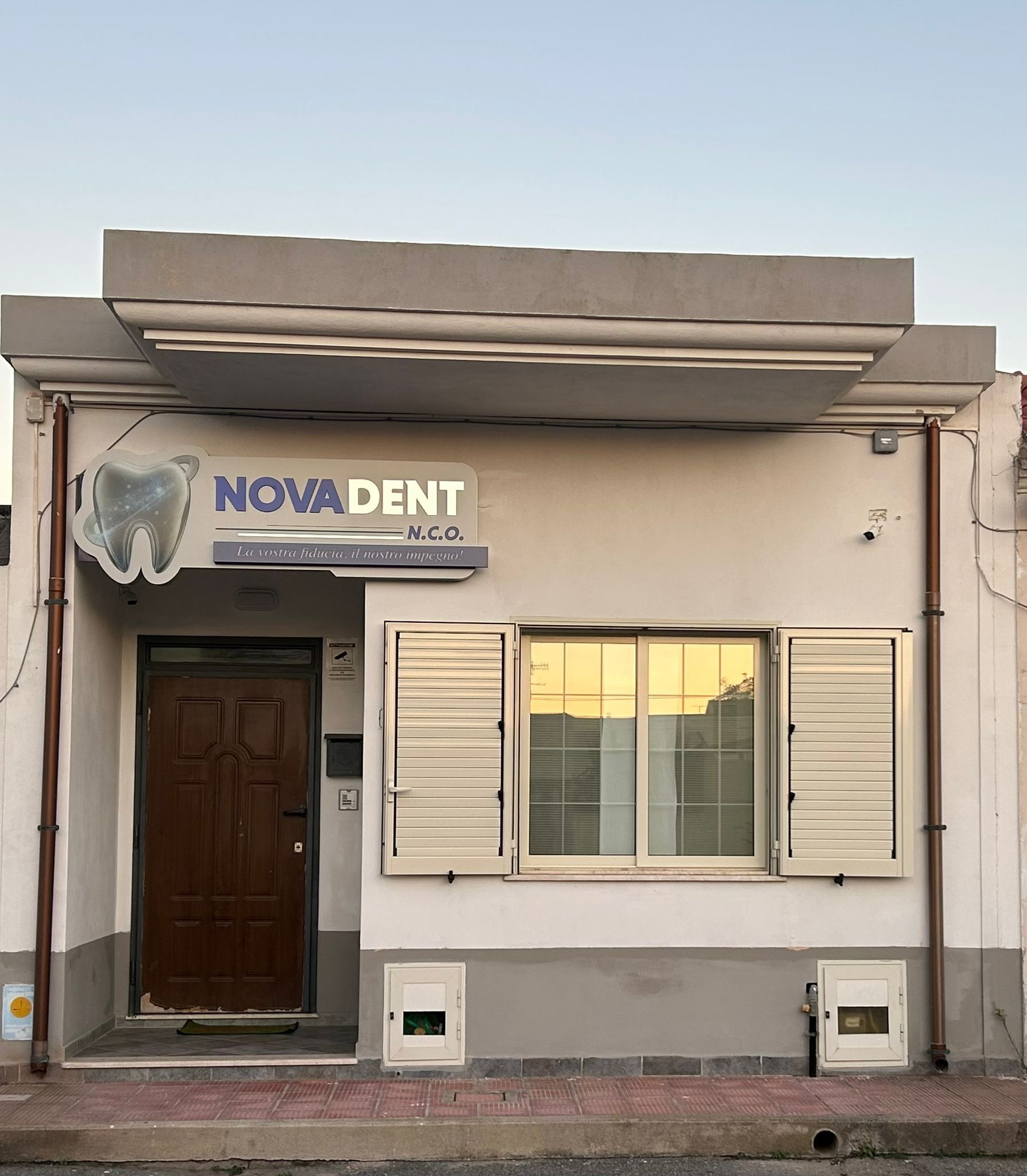 Studio dentistico Nova Dent con porta, finestra e segnaletica.