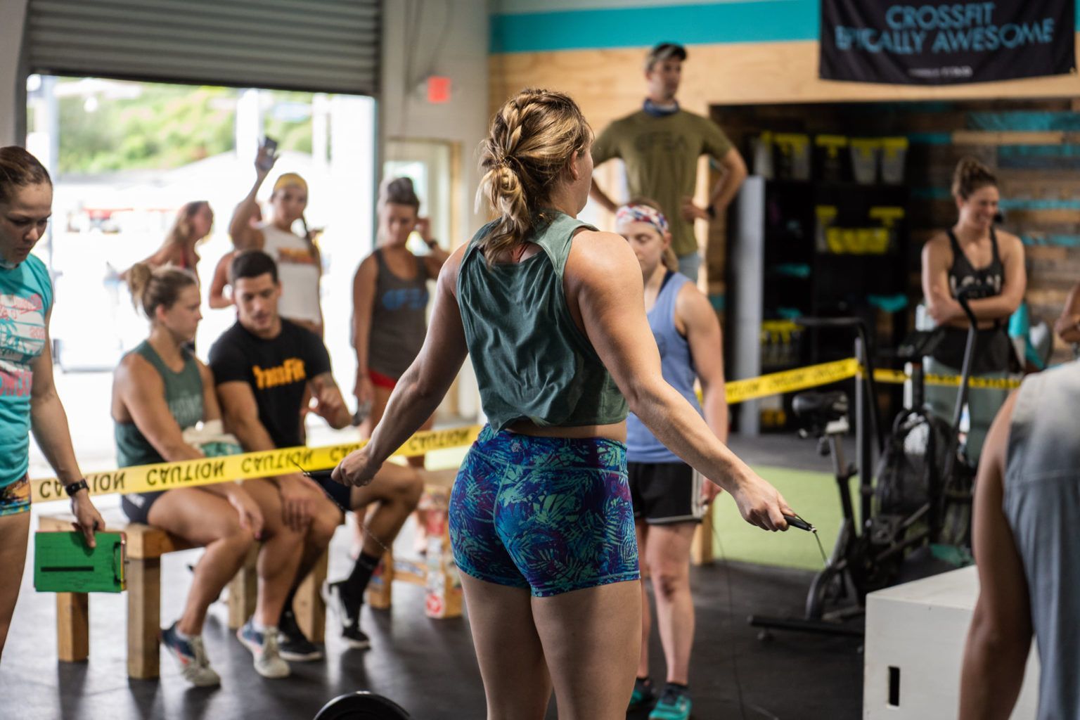 People competing in a gym event with spectators behind caution tape at the best crossfit gym in Fort Walton Beach, FL