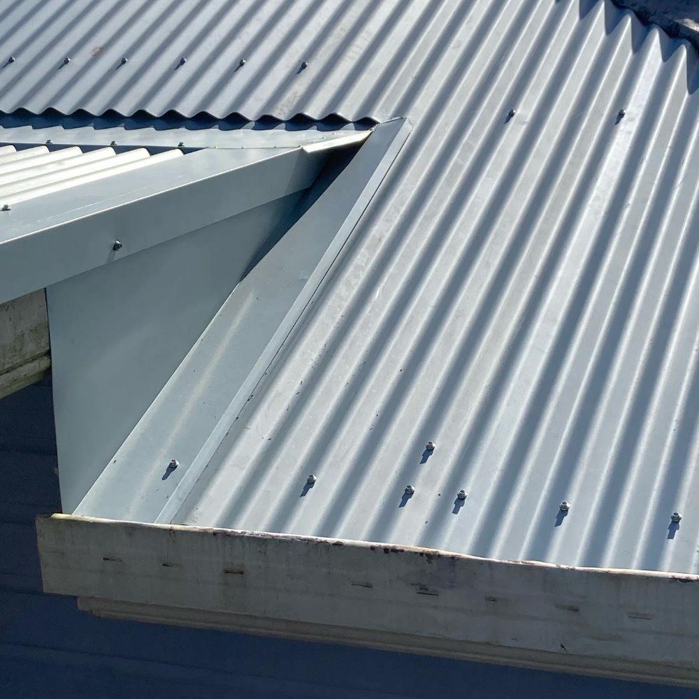 A Close Up of a Metal Roof With a Wooden Gutter — Richmond River Roofing Pty Ltd in East Ballina, NSW