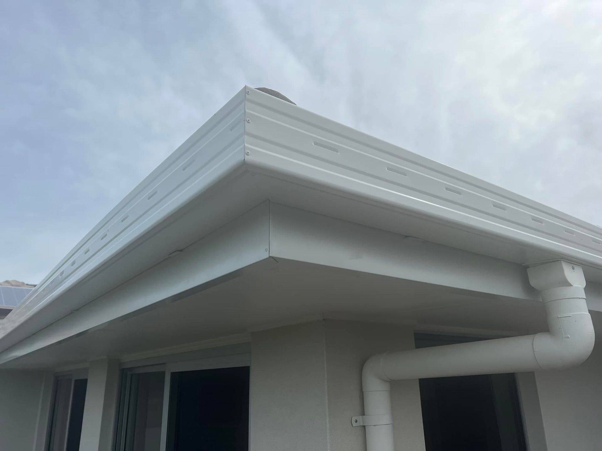 A Building With a Gutter on the Side of It — Richmond River Roofing Pty Ltd in East Ballina, NSW