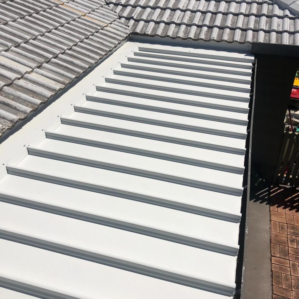 A Close Up of a White Roof With a Tile Roof in the Background — Richmond River Roofing Pty Ltd in East Ballina, NSW