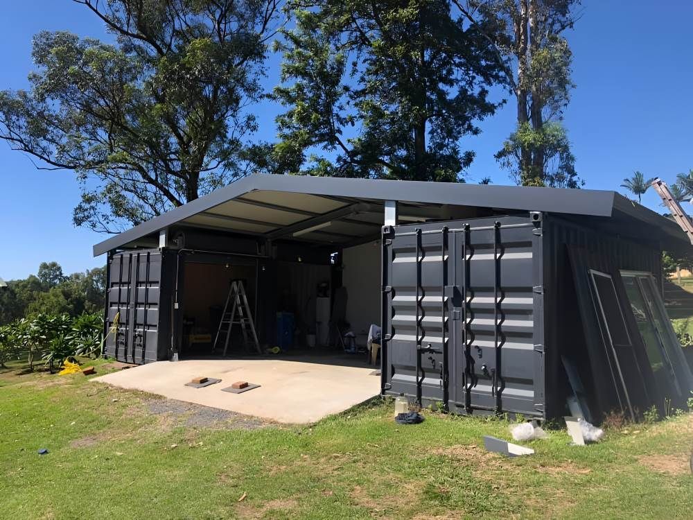 A Man is Using a Drill on a Metal Roof — Richmond River Roofing Pty Ltd in East Ballina, NSW