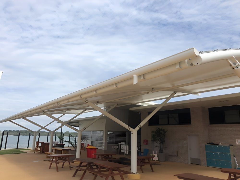 A Picnic Area With Tables and Benches Under a Canopy — Richmond River Roofing Pty Ltd in East Ballina, NSW