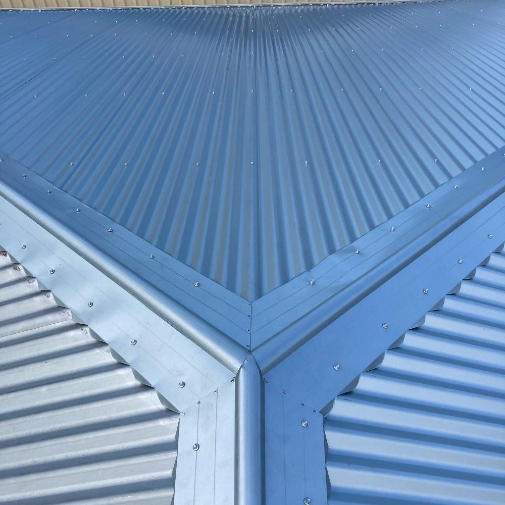 A Close Up of a Blue Corrugated Metal Roof With a Corner — Richmond River Roofing Pty Ltd in East Ballina, NSW
