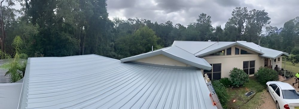 A House With a White Roof and Trees in the Background — Richmond River Roofing Pty Ltd in Northern Rivers, NSW