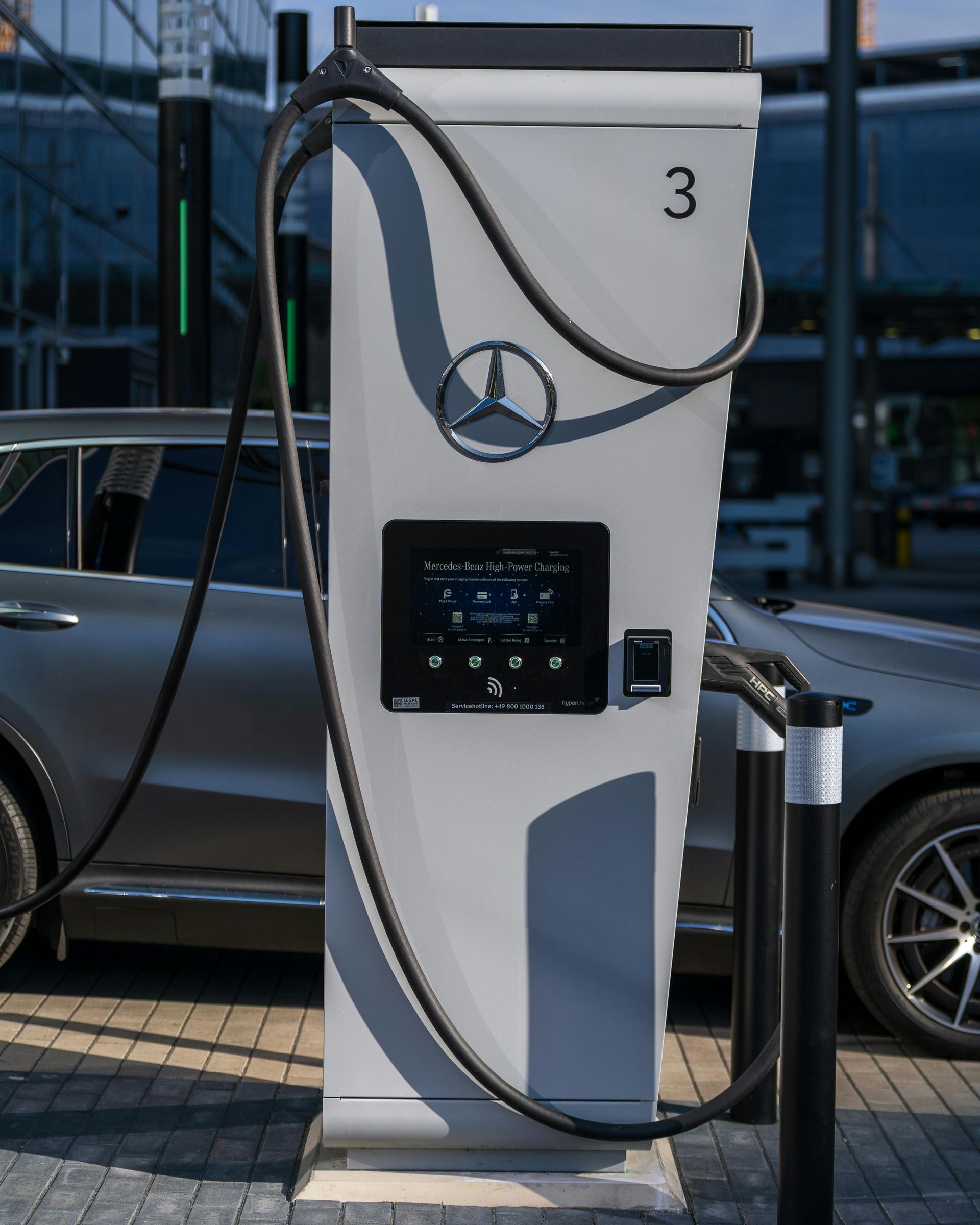 Mercedes-Benz electric vehicle charger with cable connected to gray SUV.