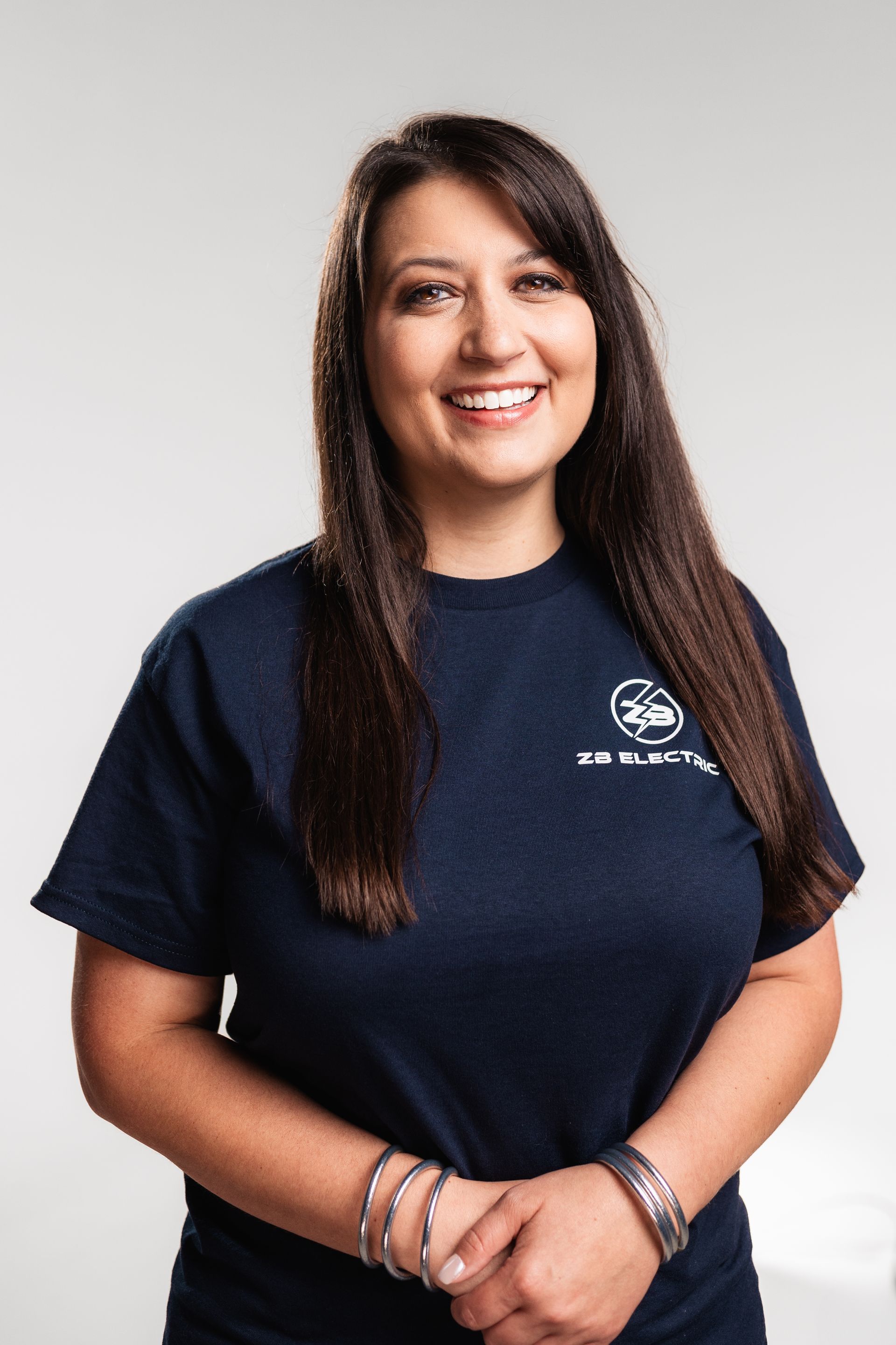 A woman wearing a blue t-shirt is smiling for the camera.