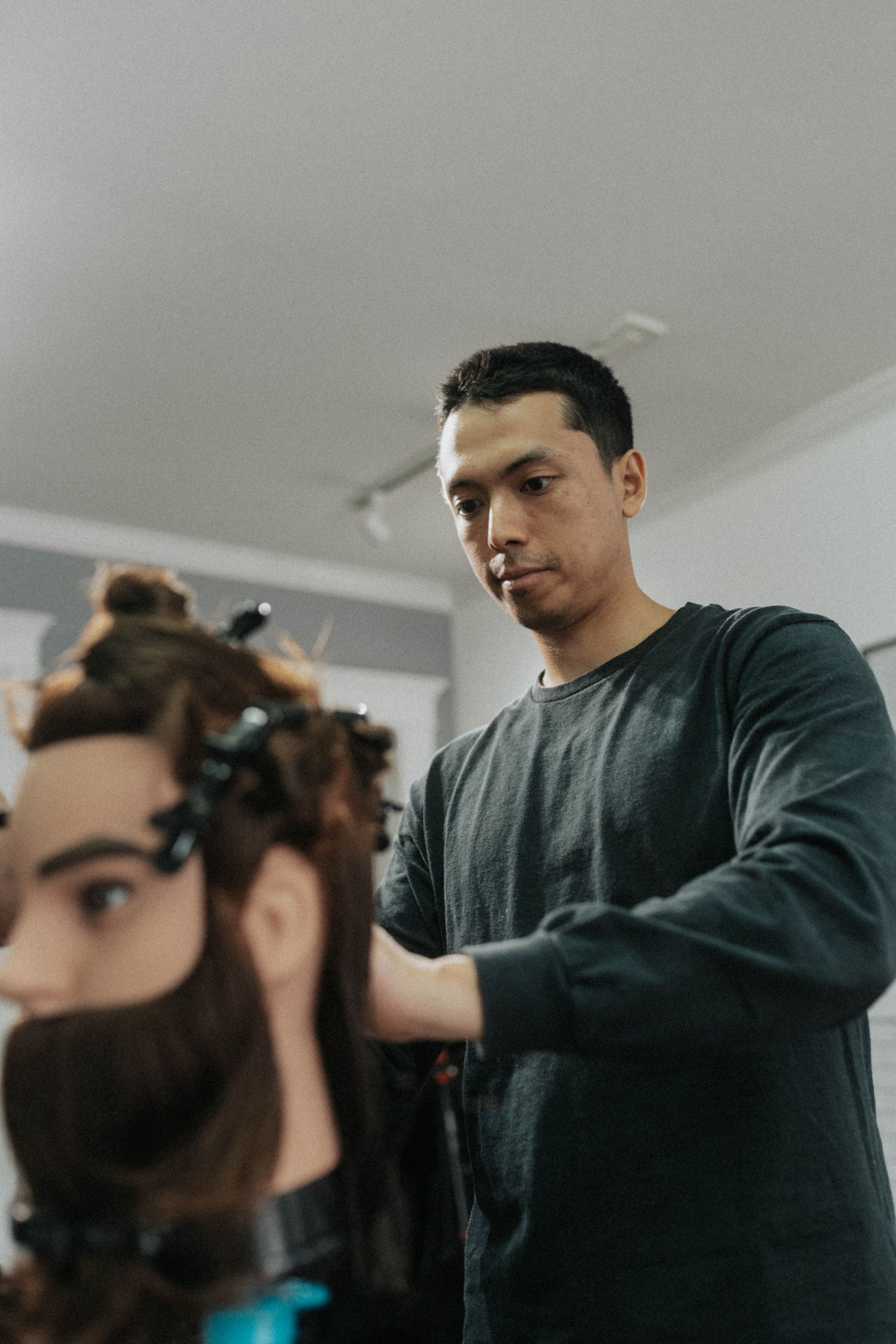 Barber styles a long hair at a professional barbershop in Long Branch NJ focusing on precision