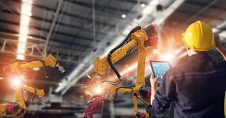 Industrial electrical repair — Engineer using tablet to control robot arms in Chino Hills, CA