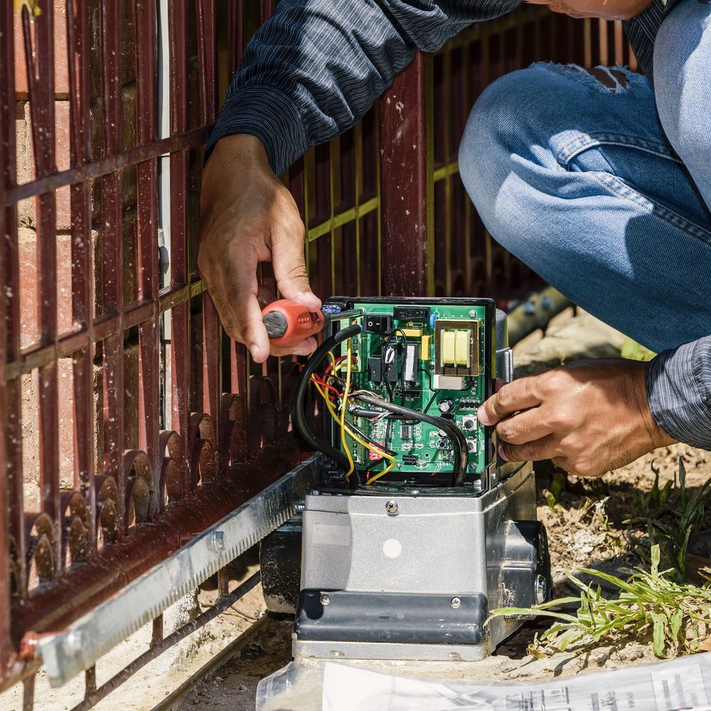 Person Repairing an Electric Gate Opener Using a Screwdriver — Elibon Solutions in Garbutt, QLD