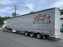 A Man Is Driving A Forklift In A Warehouse — Pegar Transport In Sydney, NSW