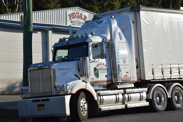 A White Semi Truck Is Parked In Front Of A Building That Says Pegad — Pegar Transport In Port Macquarie, NSW