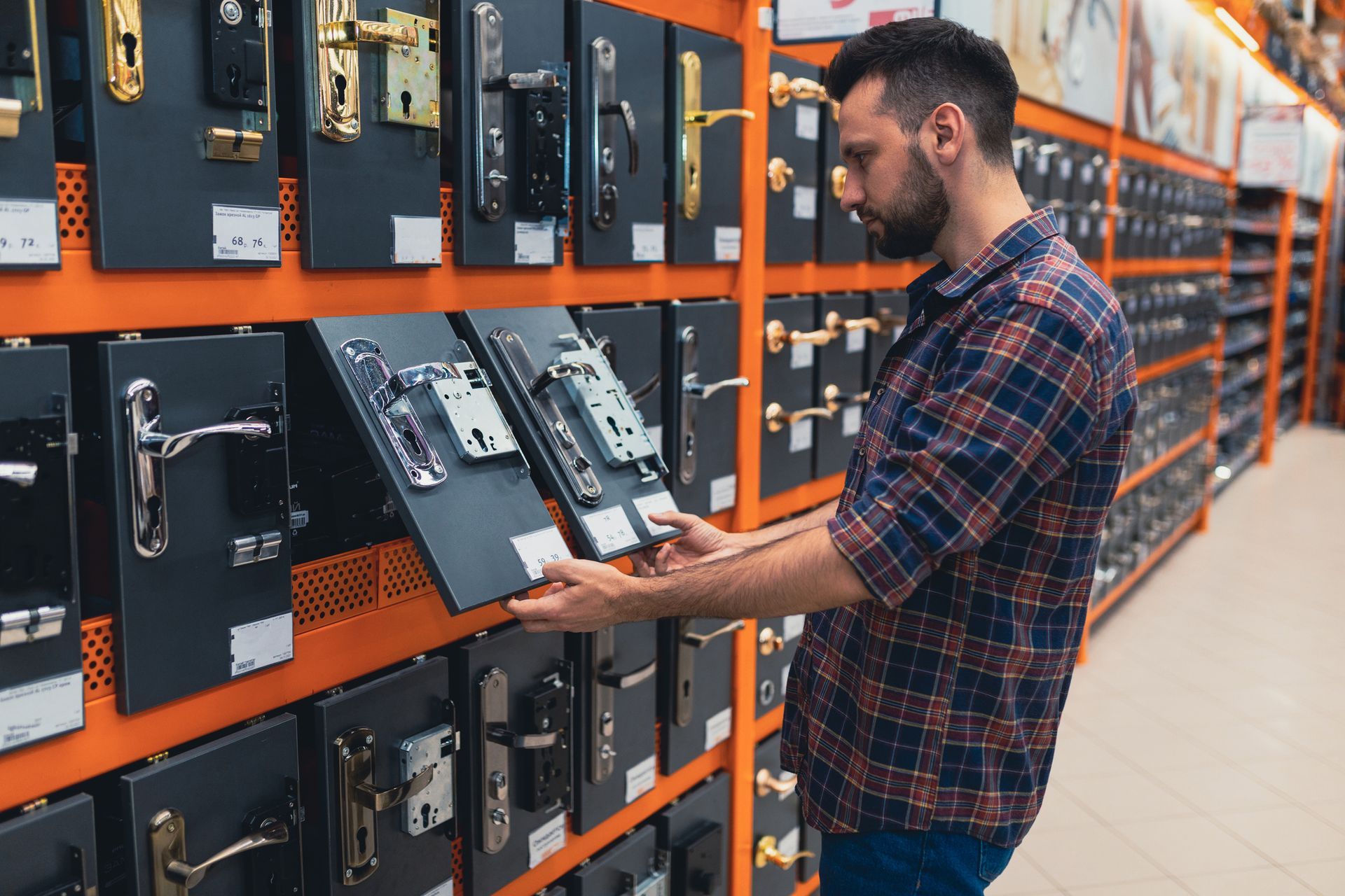 Construction shop shopper next to a rack with doorknobs and locks.