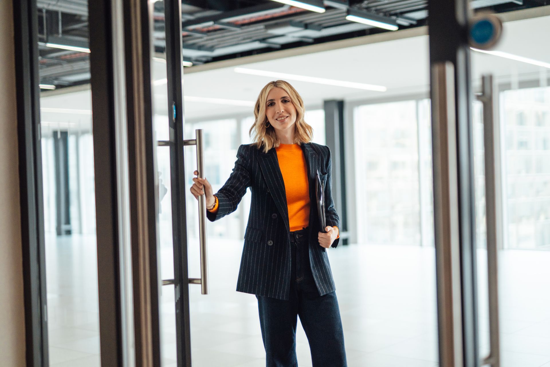 Young female estate agent showing client a modern office rental