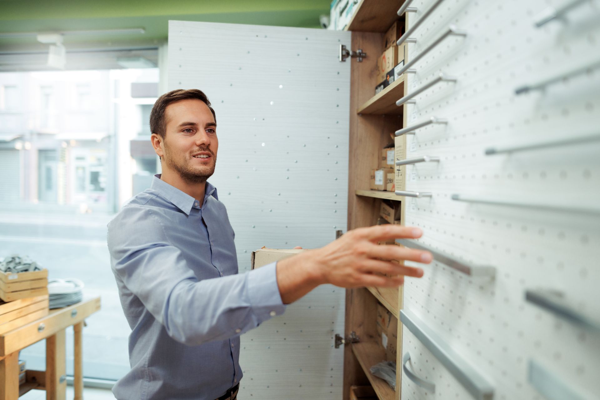 A man is looking at cabinet handles in a store.