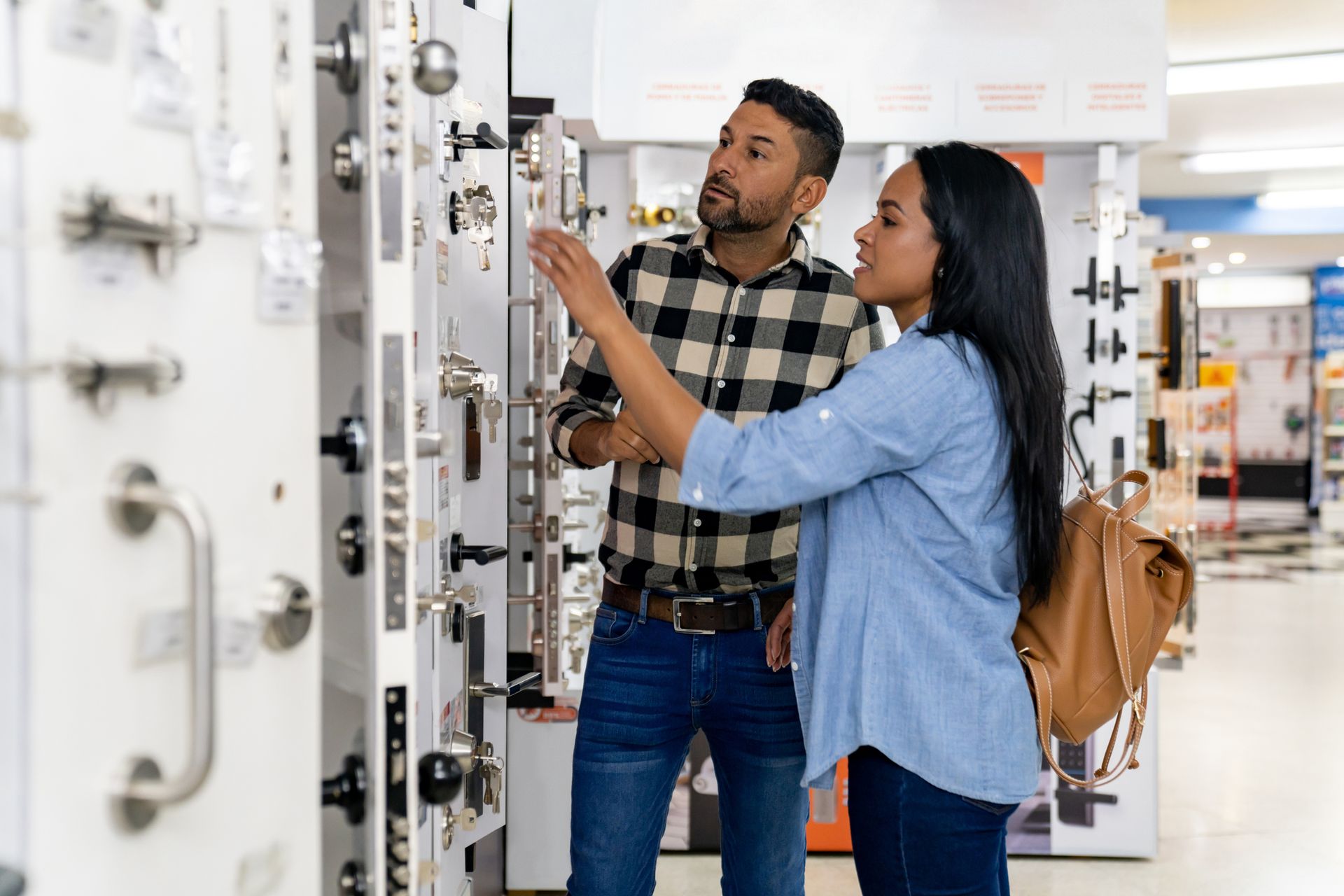 Couple looking at security locks for their house at a hardware store.