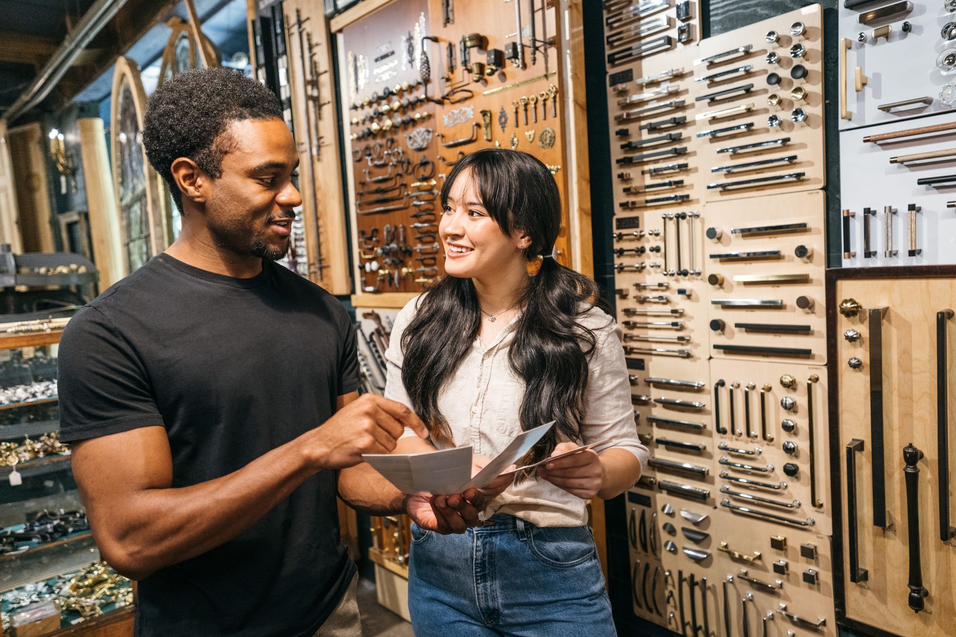 A salesman is helping a customer choose hardware from a store display.