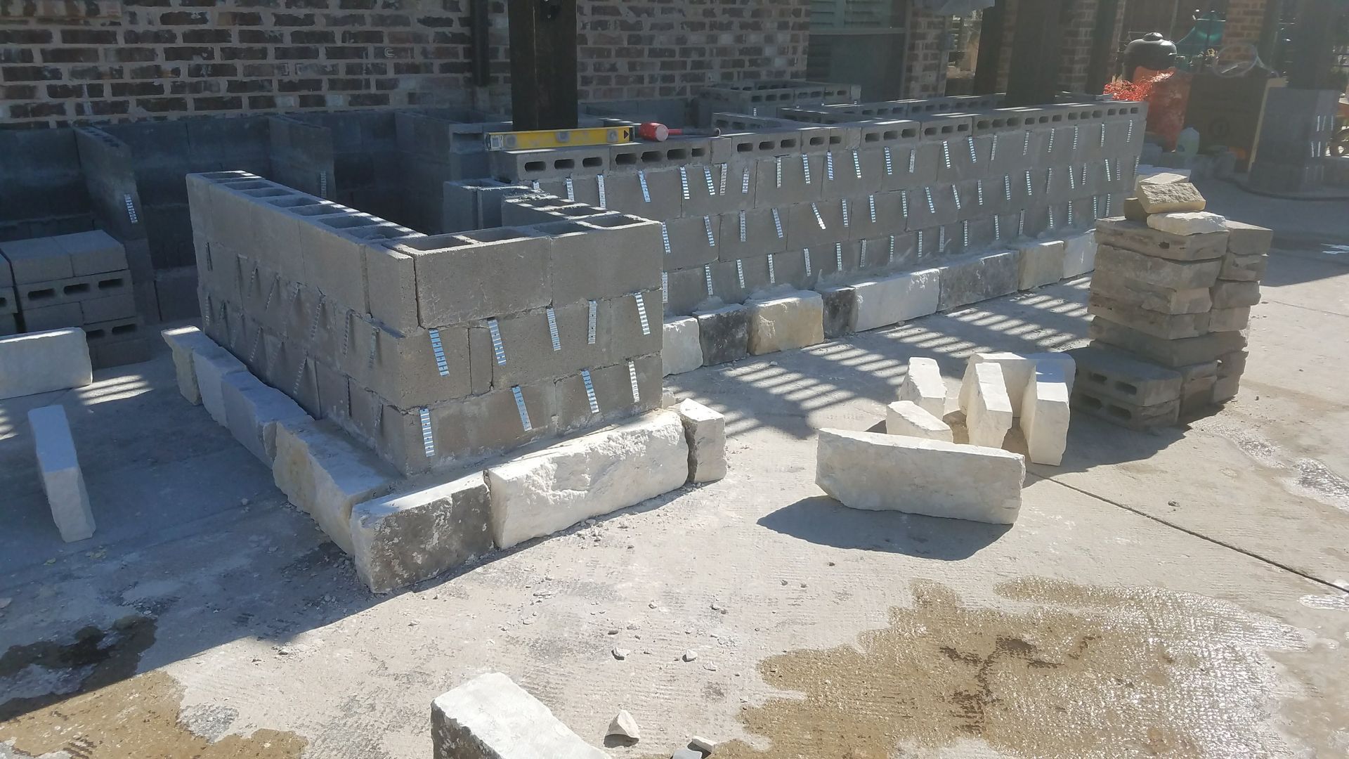 Construction site with concrete blocks being laid; exterior of a building under construction.