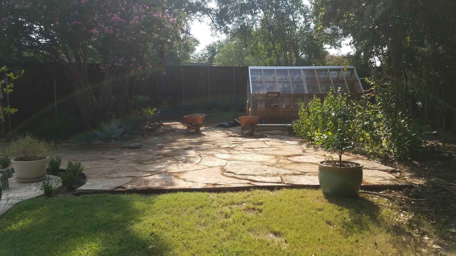 A Backyard with a Greenhouse and Two Wheelbarrows - Tulsa, OK - Outdoor Orchestrators