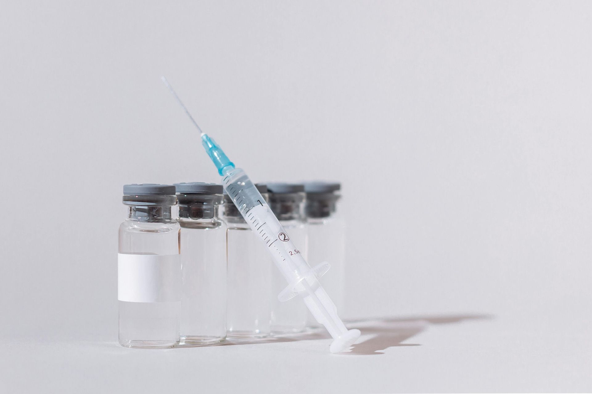 Lyophilized peptide vials with sterile syringe in lab research setting