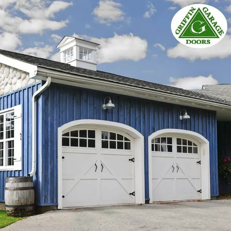 A blue garage with white doors and a griffin garage doors logo