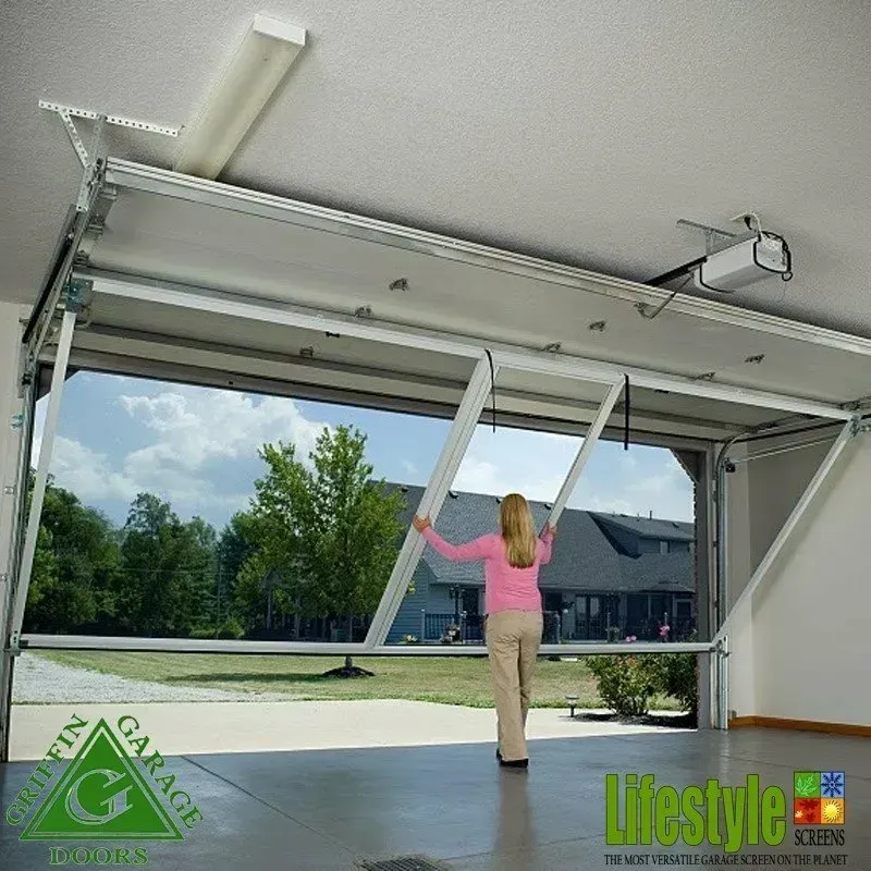 A woman in a pink shirt is standing in front of a garage door that is open