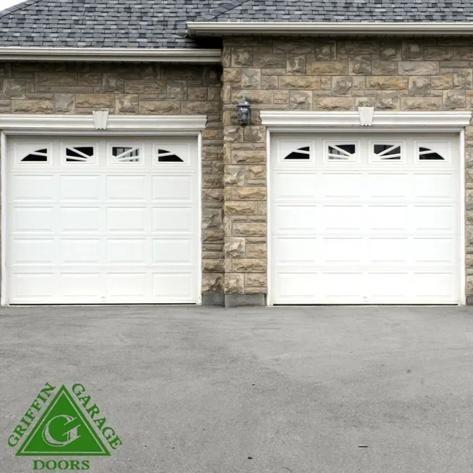 Two white garage doors with a griffin garage doors logo