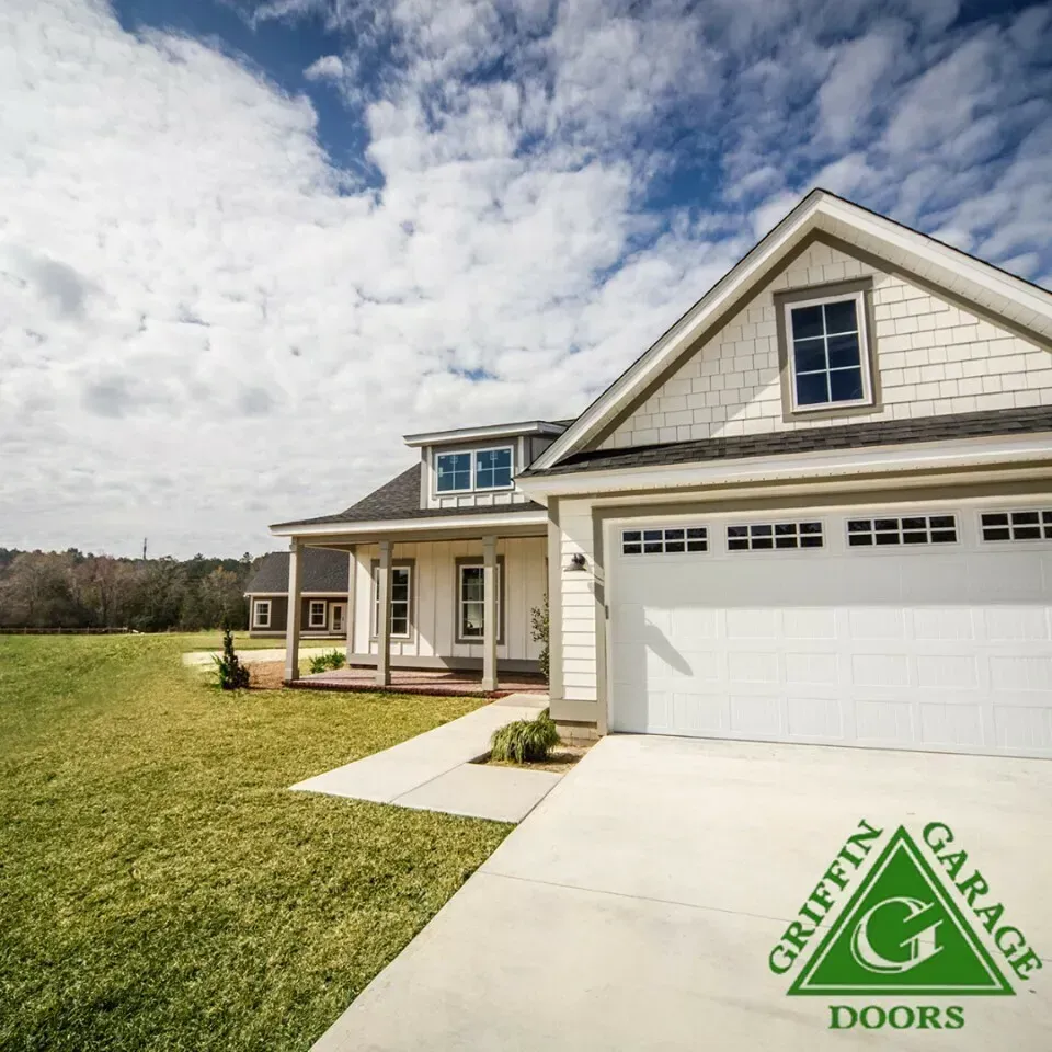 A white house with a griffin garage doors logo in front of it