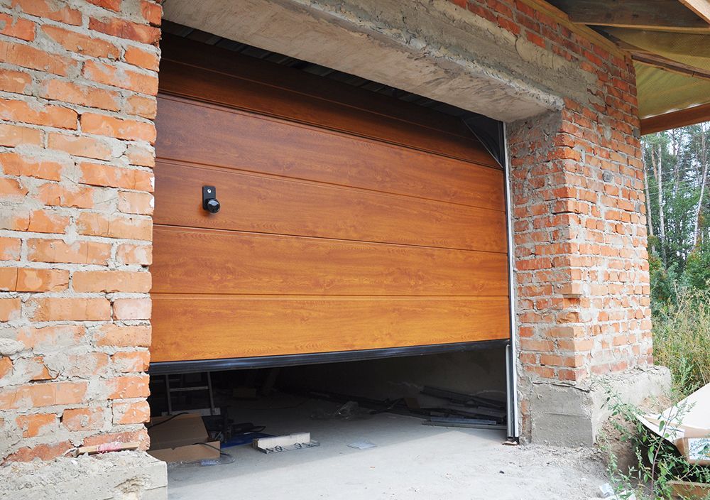 A wooden garage door is open in a brick building.