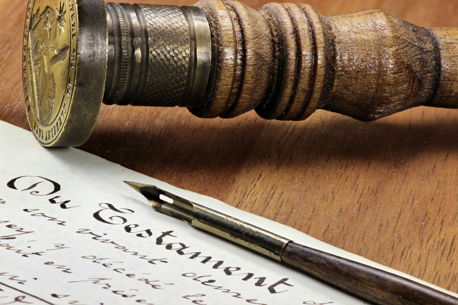 Wachssiegel und Stempel mit Holzgriff über einem handgeschriebenen Testament, im Vordergrund ein Stift.